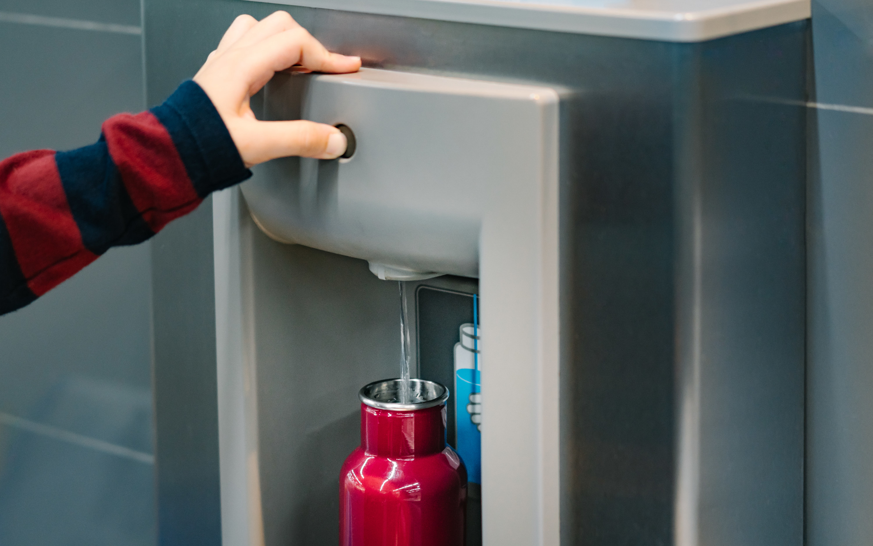 a person filling a water bottle