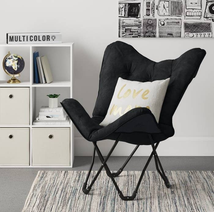The chair in black with an accent pillow