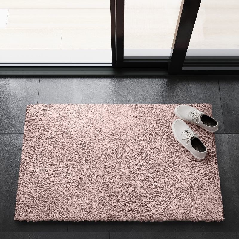 the rug in pink with shoes on it