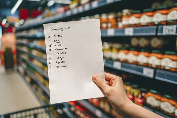 shopping list in hand of woman in grocery store