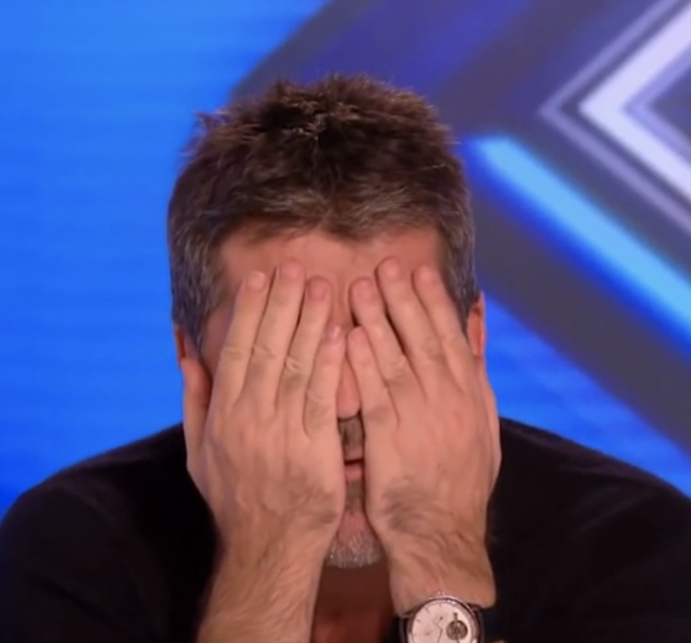 Simon Cowell covering his face with his hands