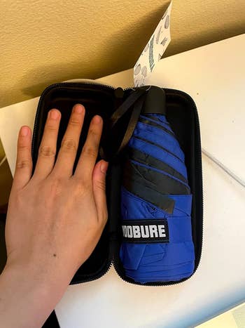reviewer's photo of the mini umbrella in the case