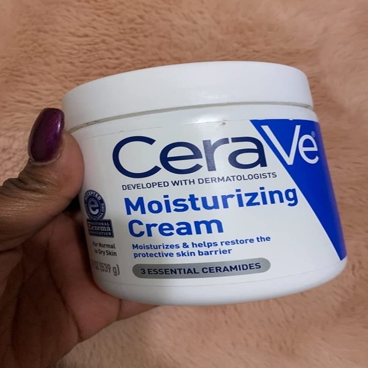 Reviewer holding cream bottle