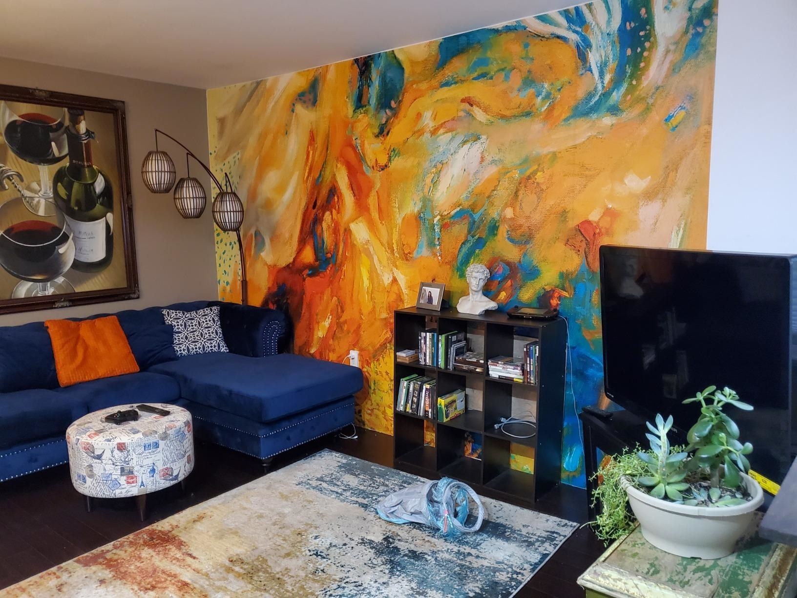 reviewer&#x27;s living room wall covered with the colorful mural