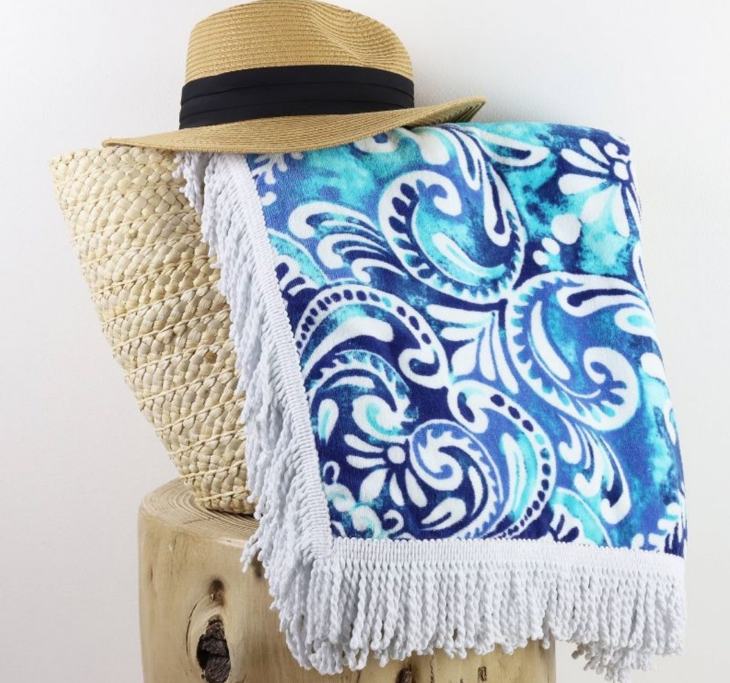 A blue paisley beach towel with fringe