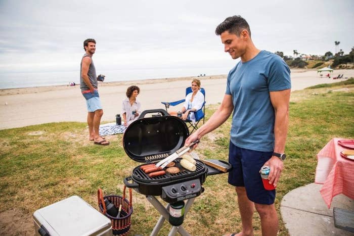 A model grilling on a gas grill at the beach