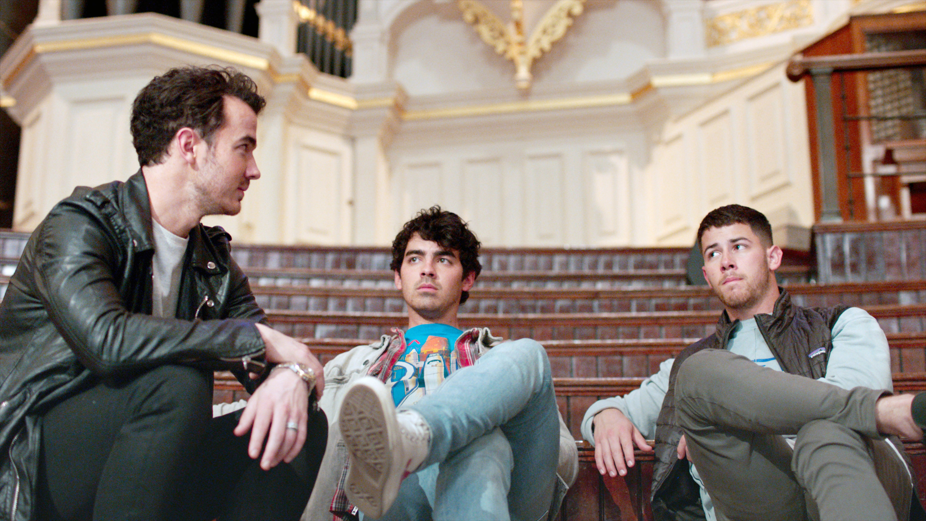 The Jonas Brothers sit on steps together