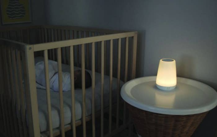 The nightlight glowing a warm white next to baby sleeping in a crib