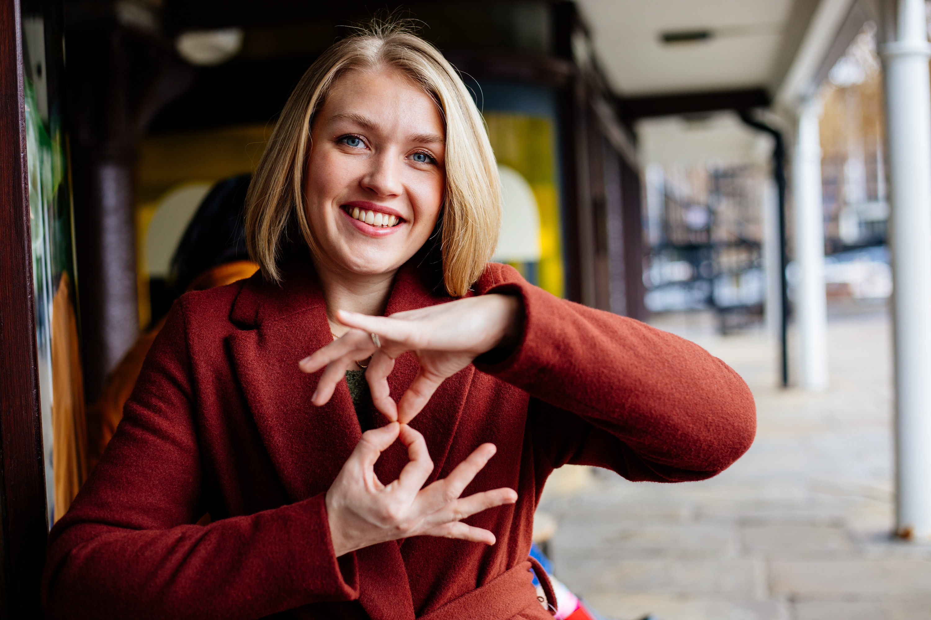 A smiling woman using sign language