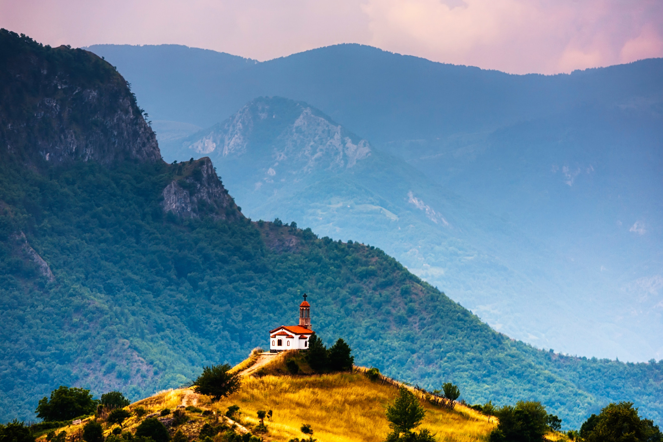 a church surrounded by mountains
