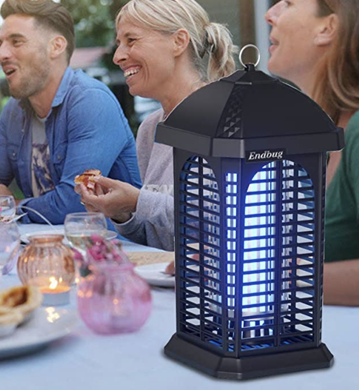 the bug zapper on a table next to people eating