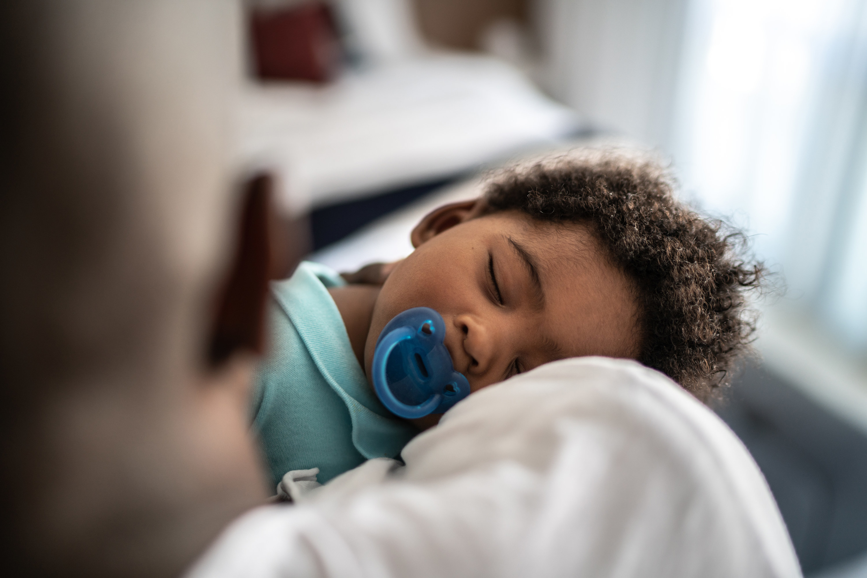 A child sleeping with a teething ring