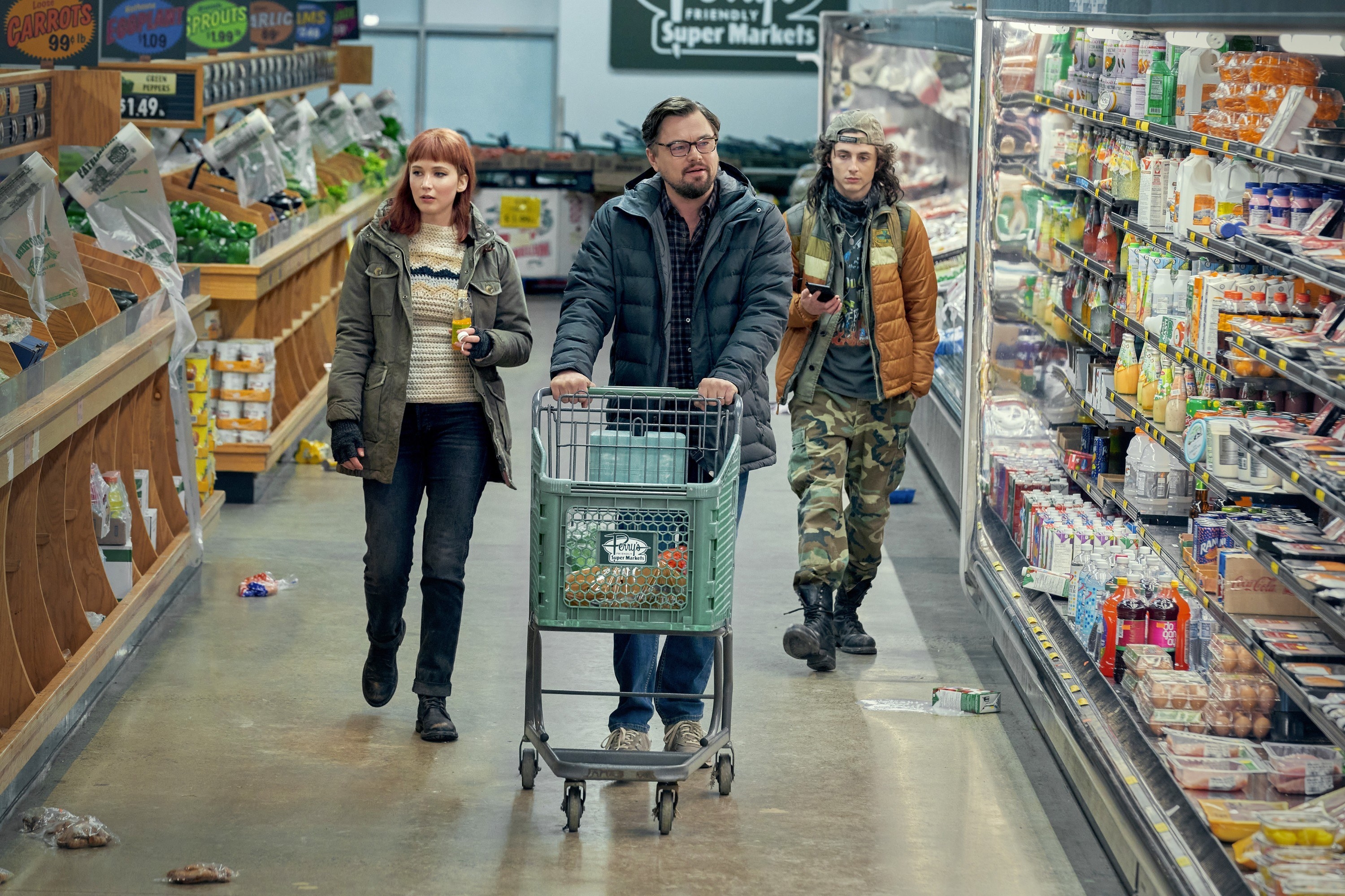 The characters from Don&#x27;t Look Up walking through a grocery store with many items gone and trash littering the floor