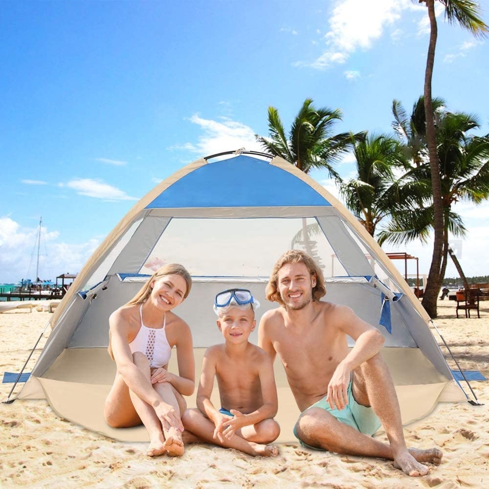 a family sitting under the shelter at a beach