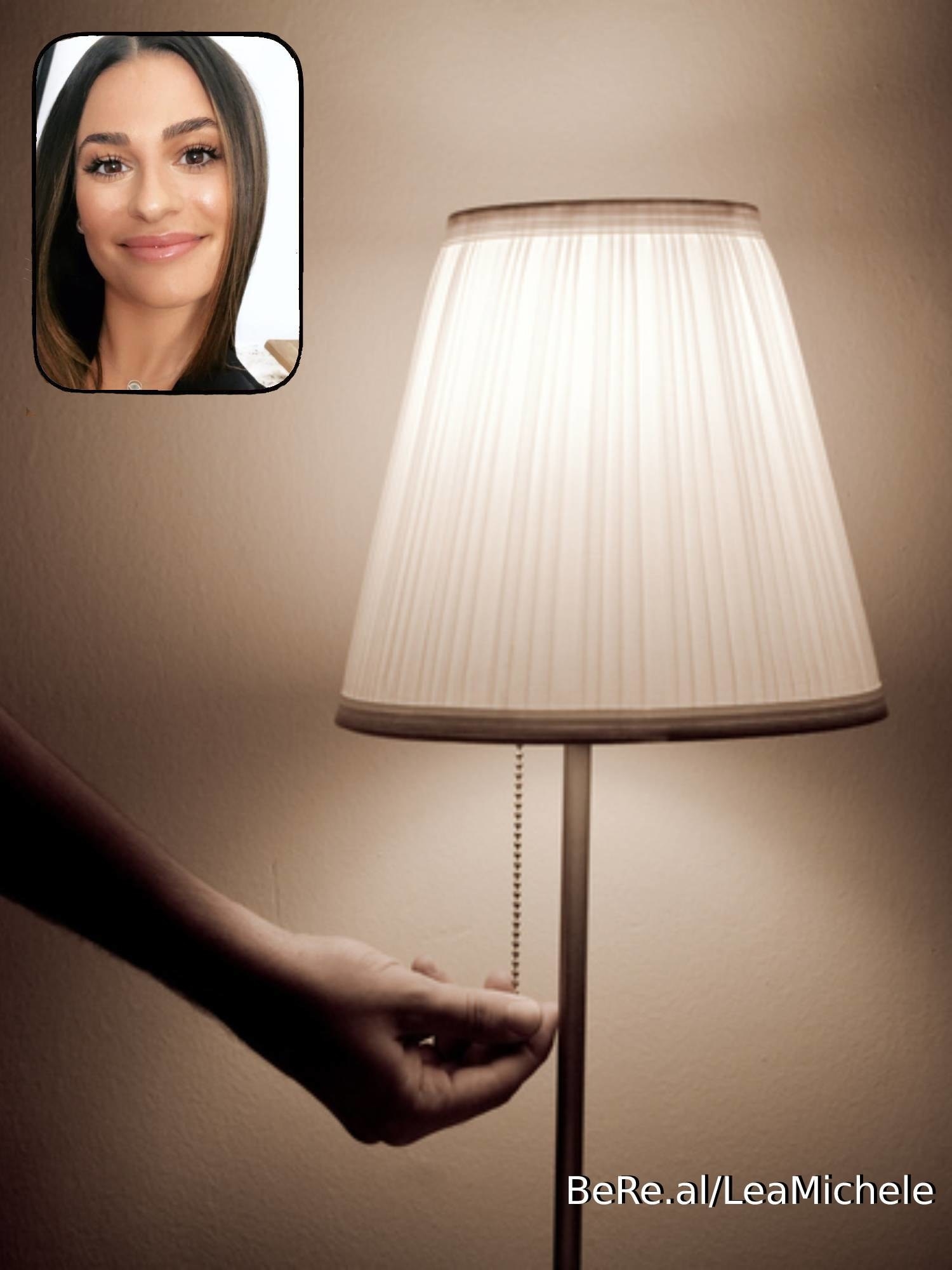 Lea Michele smiling as someone turns on a lamp