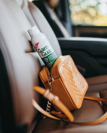 bottle of garma guard in a purse in the seat of a car