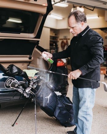 person spraying golf clubs with garma guard