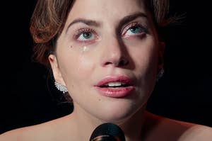 Lady Gaga crying as she sings and look up as Ally in A Star Is Born