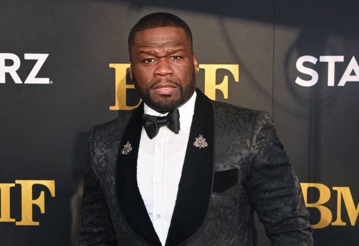 50 Cent poses on the red carpet while wearing a tuxedo