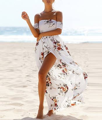 model in a long flowy off shoulder white dress with floral pattern