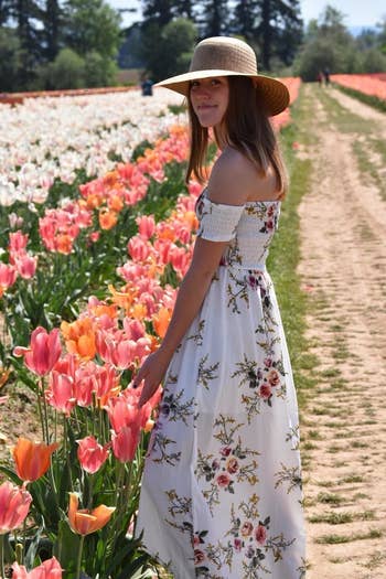 reviewer wearing the long white off shoulder flowy dress