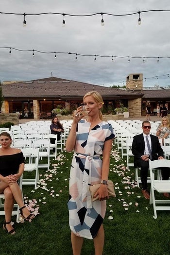 reviewer wearing the dress and posing at a wedding