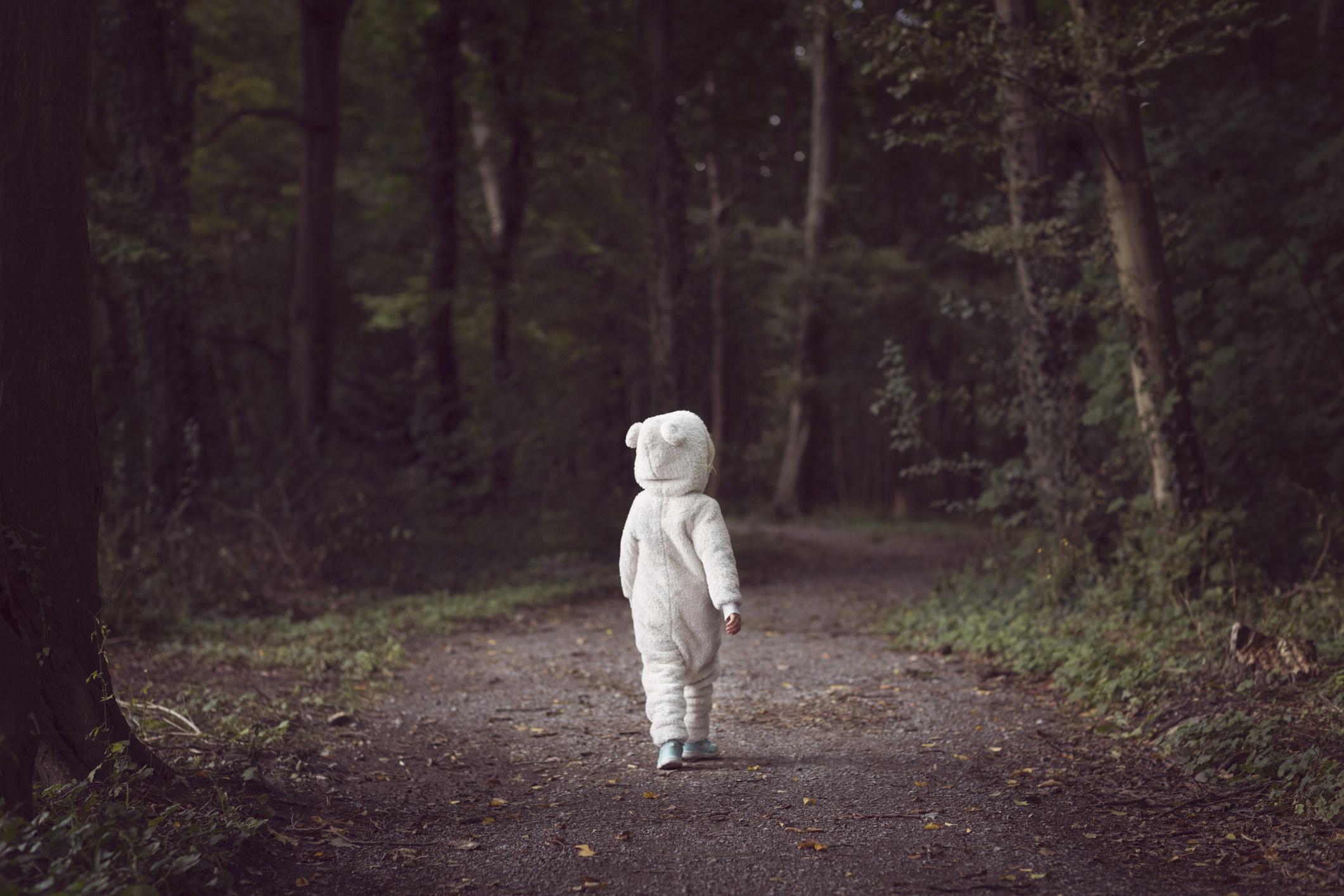 A child in a costume walking in the woods
