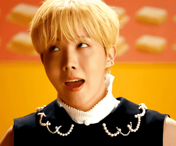 J-Hope smiles and sings in the &quot;Butter&quot; music video