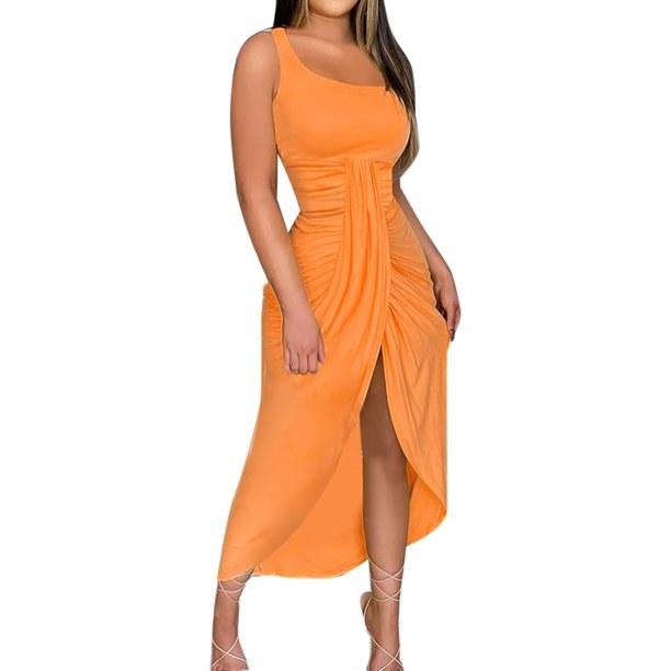 Woman wearing an orange dress with ruching and front slit