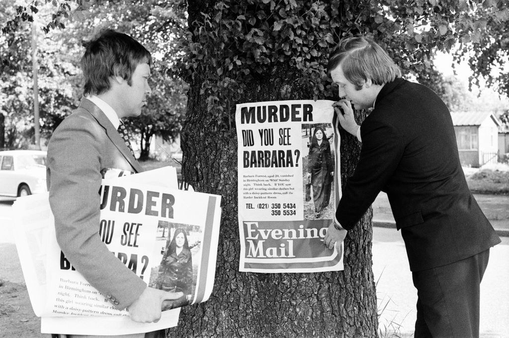 Men hanging up signs for Barbara who was murdered
