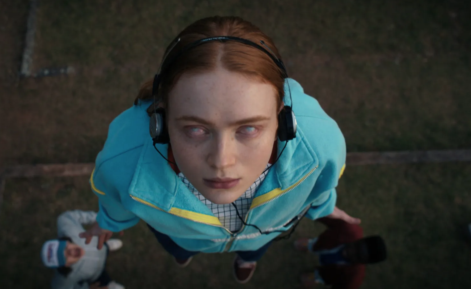 A close-up of Max Mayfield with her eyes rolled back in her head while wearing headphones
