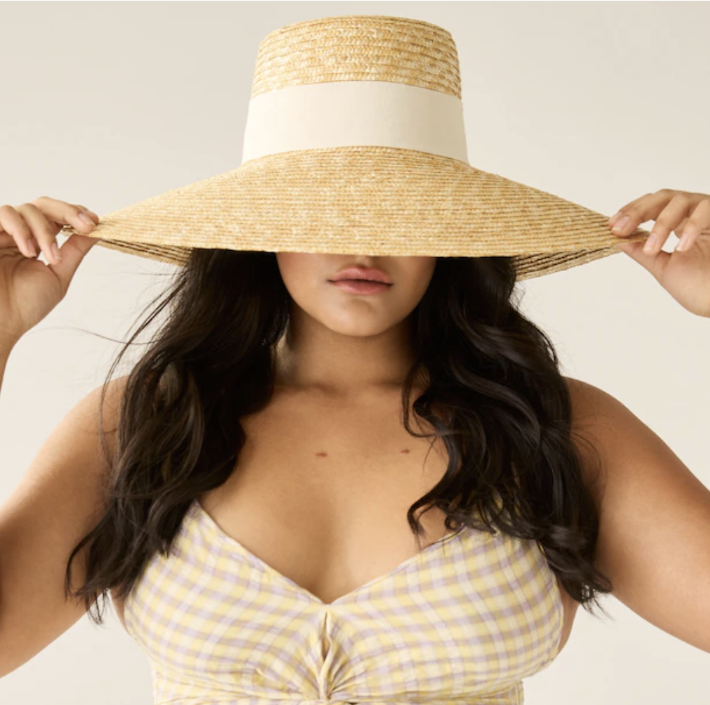 a person wearing the sun hat in front of a plain background