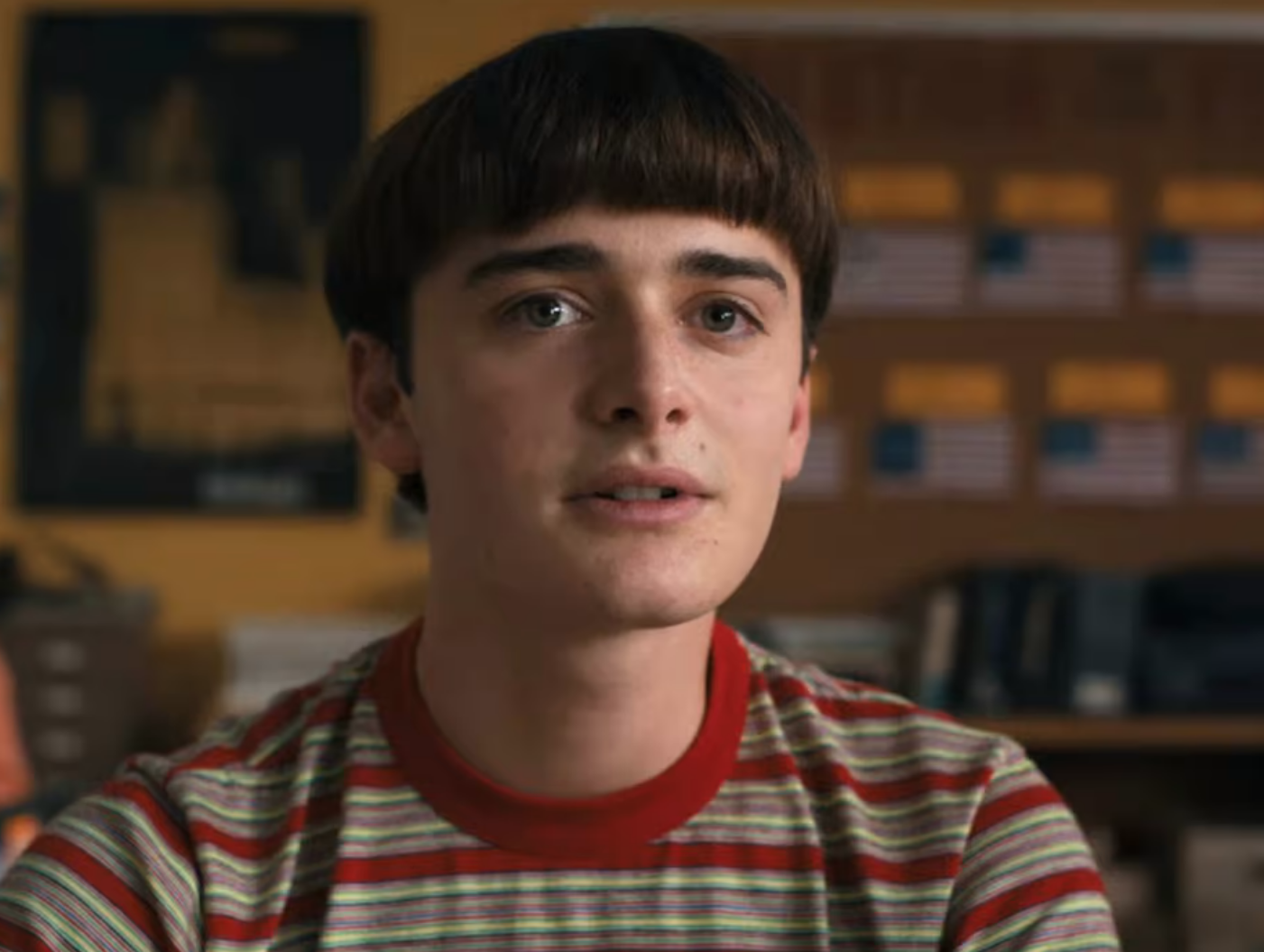 A close-up of Will Byers in a short-sleeved striped shirt