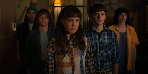 Argyle, Jonathon Byers, Will Byers, and Mike Wheeler stand in a group behind Eleven