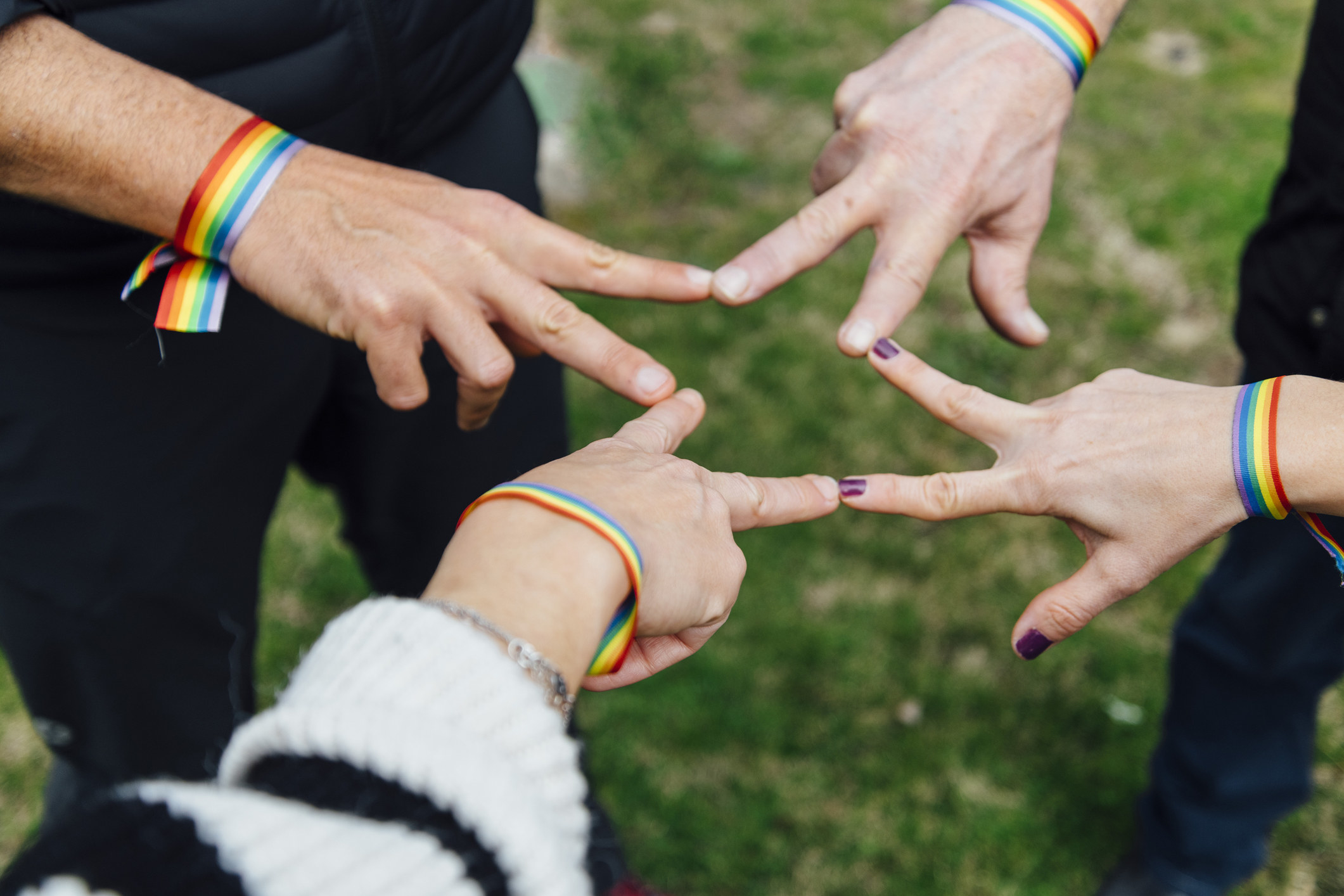 People wearing Pride bracelets