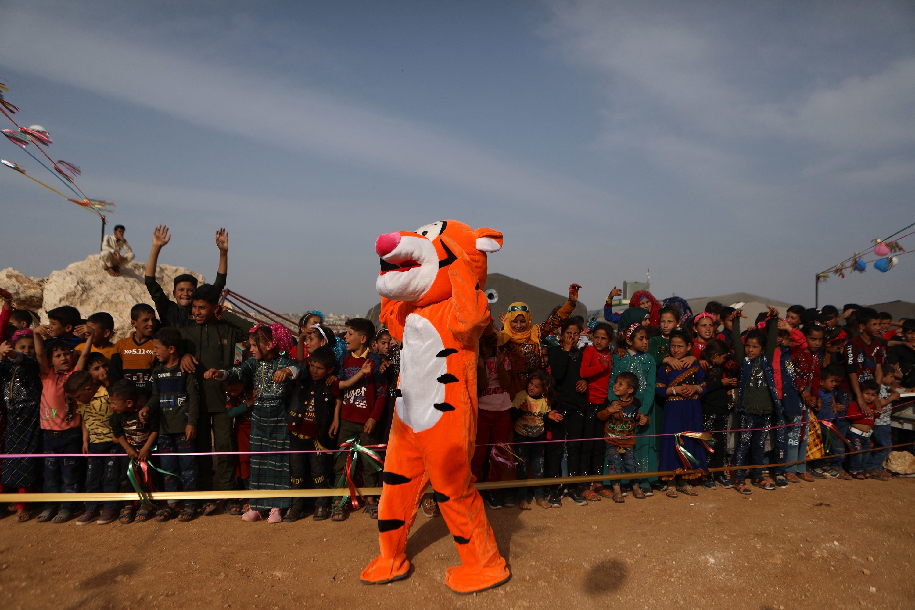 A person dressed as Tigger stands in front of a crowd