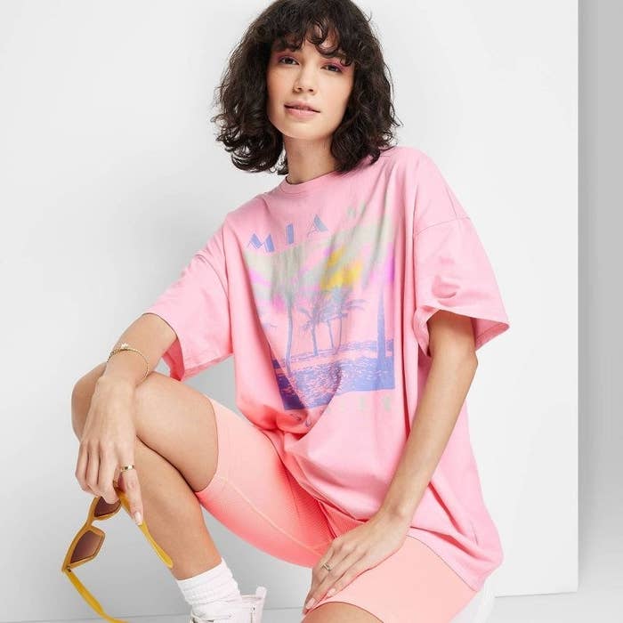 The model wears the pink oversized T-shirt