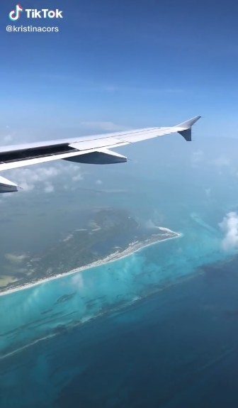 Wing of an airplane over the blue ocean