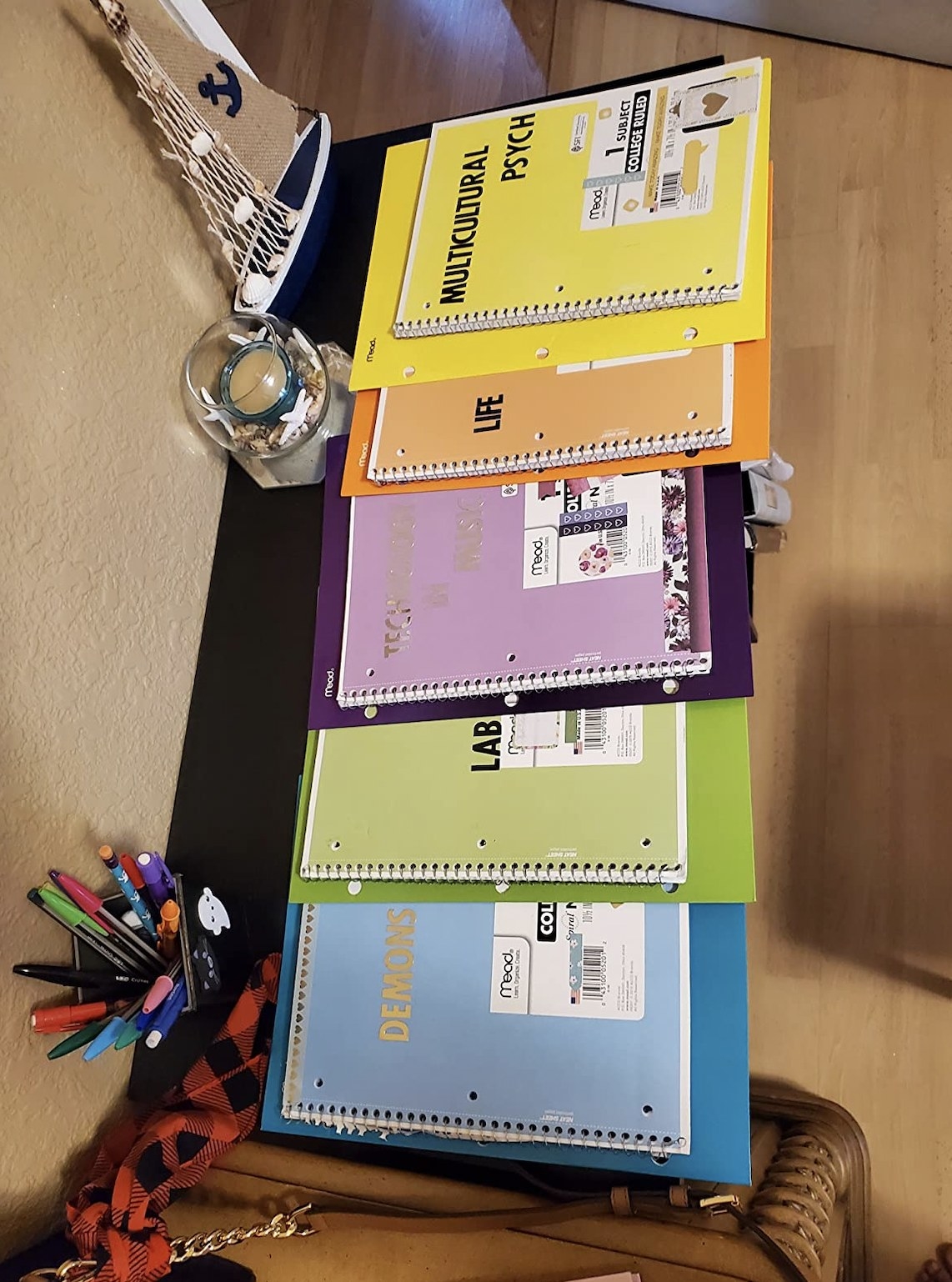 Reviewer&#x27;s photo showing the five folders all laying underneath color-matching notebooks