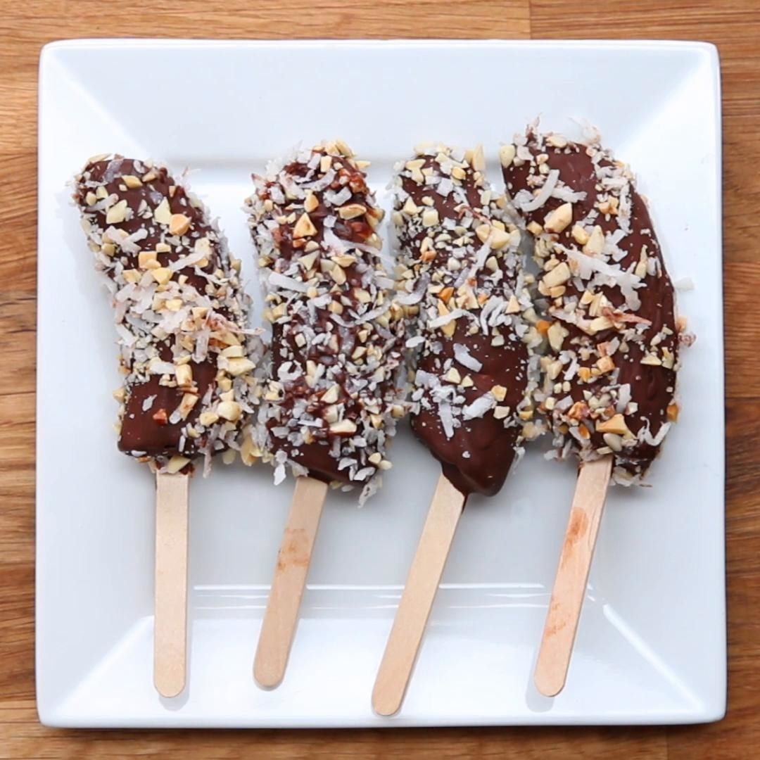 Chocolate dipped banana ice pops with nuts and coconut.