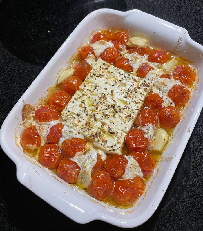 Cherry tomatoes and feta cheese in a baking dish.