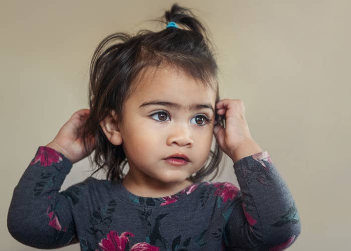 A little girl with her hands in her hair