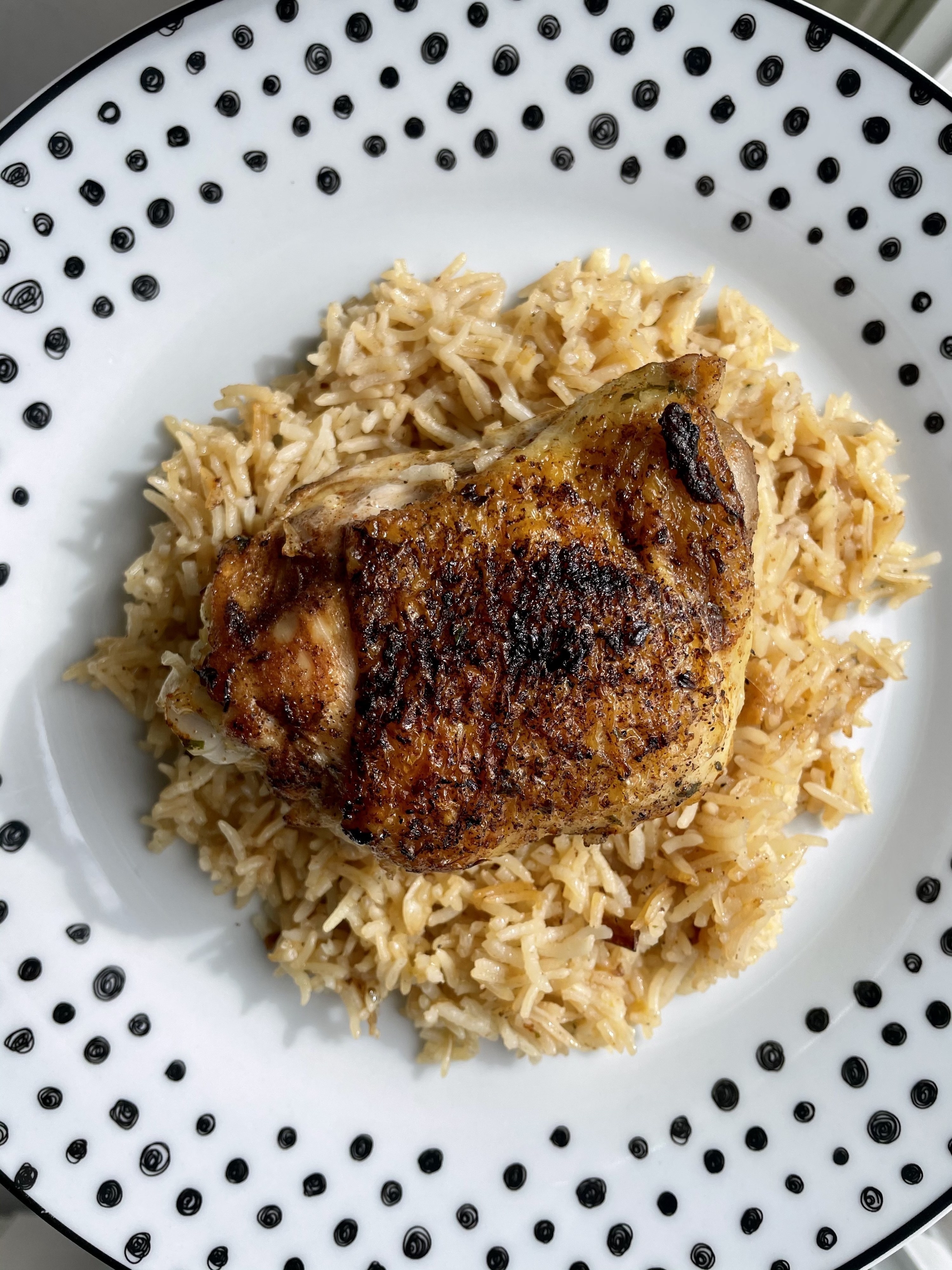 A chicken thigh over rice.