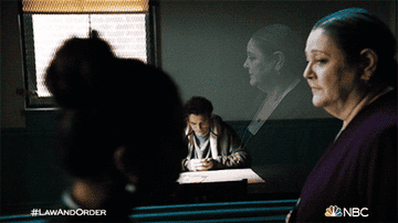 Woman looks at man in interrogation room