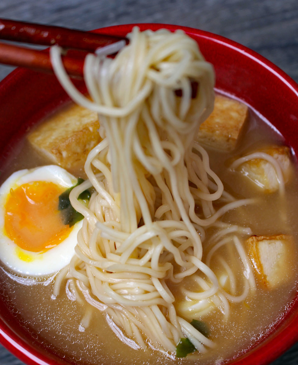 A bowl of ramen noodles with soft boiled egg.