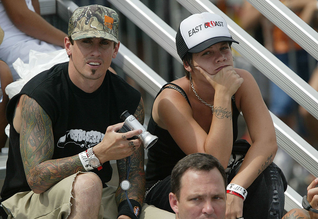Carey and Pink wearing caps and sitting in the stands at an event