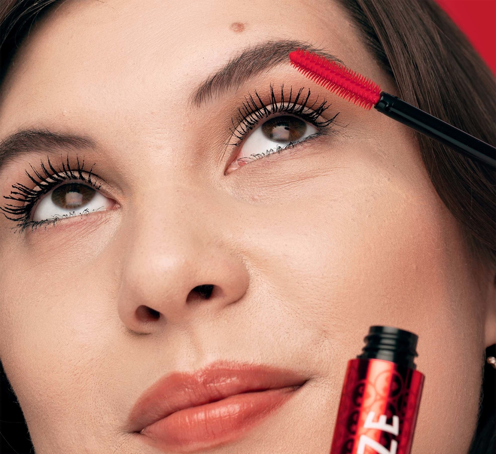 a close up of a model applying the mascara