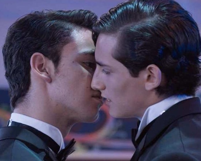 Dos hombres jóvenes besándose