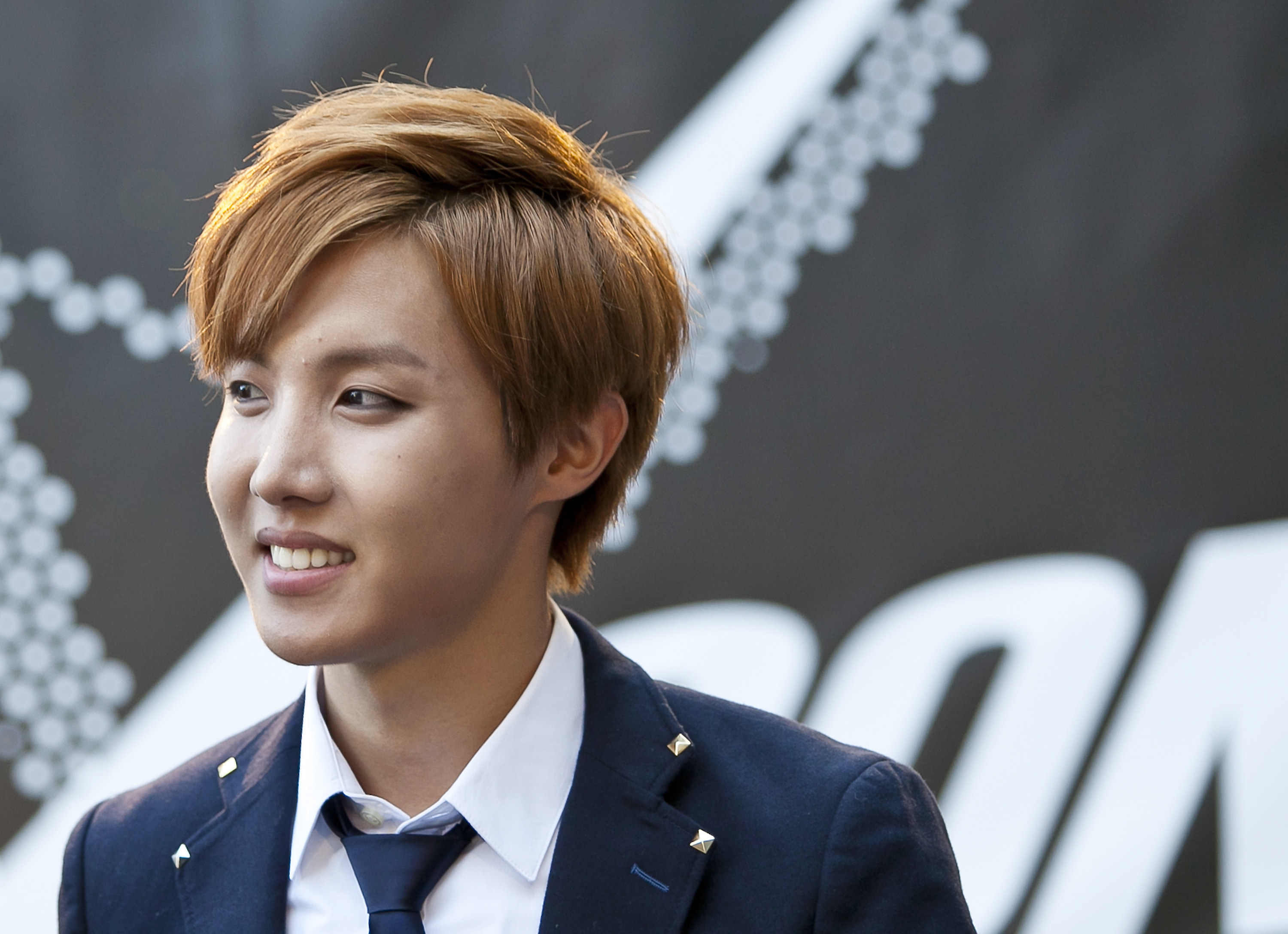 Close-up of J-Hope looking to the side and smiling; photo is from 2014