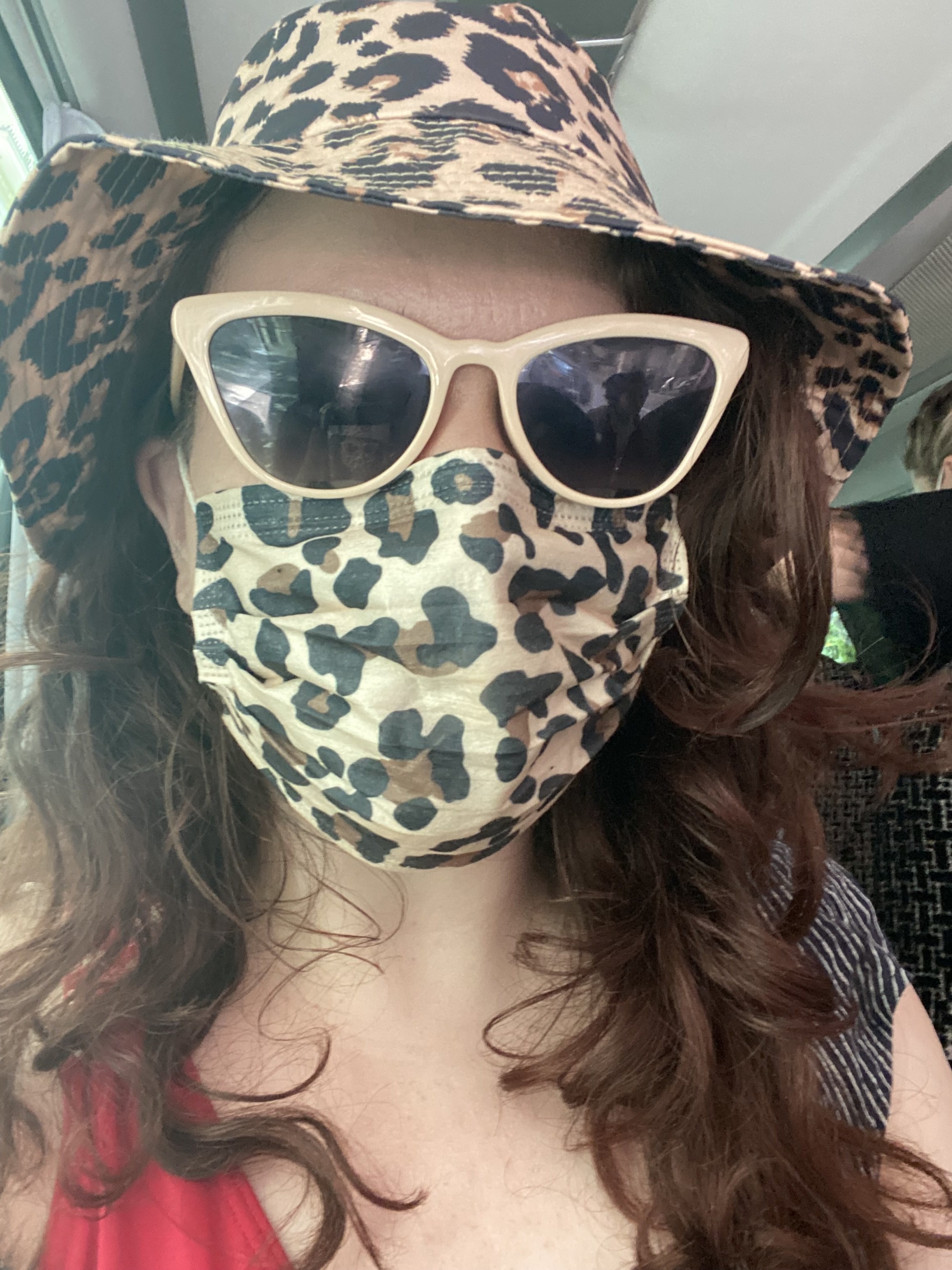 writer wearing an animal print bucket hat and matching mask with sunglasses